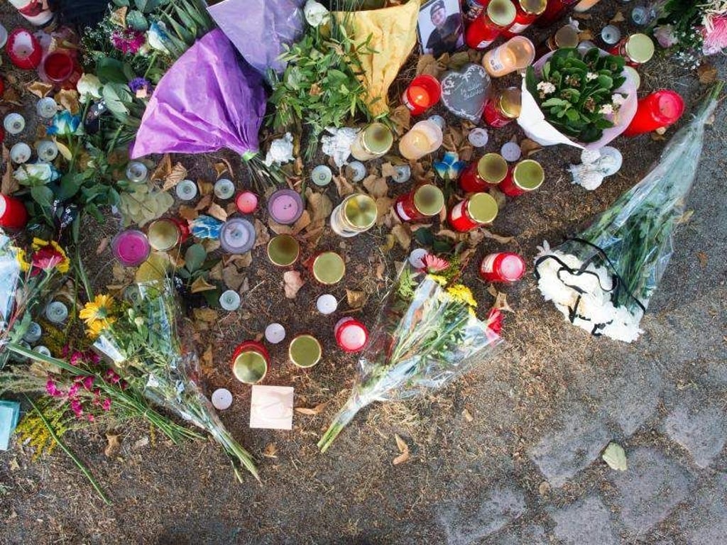 Blumen und Kerzen liegen auf dem Boden. Foto: Klaus-Dietmar Gabbert/Archiv