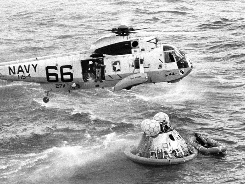 Ein Hubschrauber der Navy schwebt bei der Bergung der zurückgekehrten Astronauten über der Apollo 11-Kapsel. Foto: Milt Putnam/U.S. Navy/AP