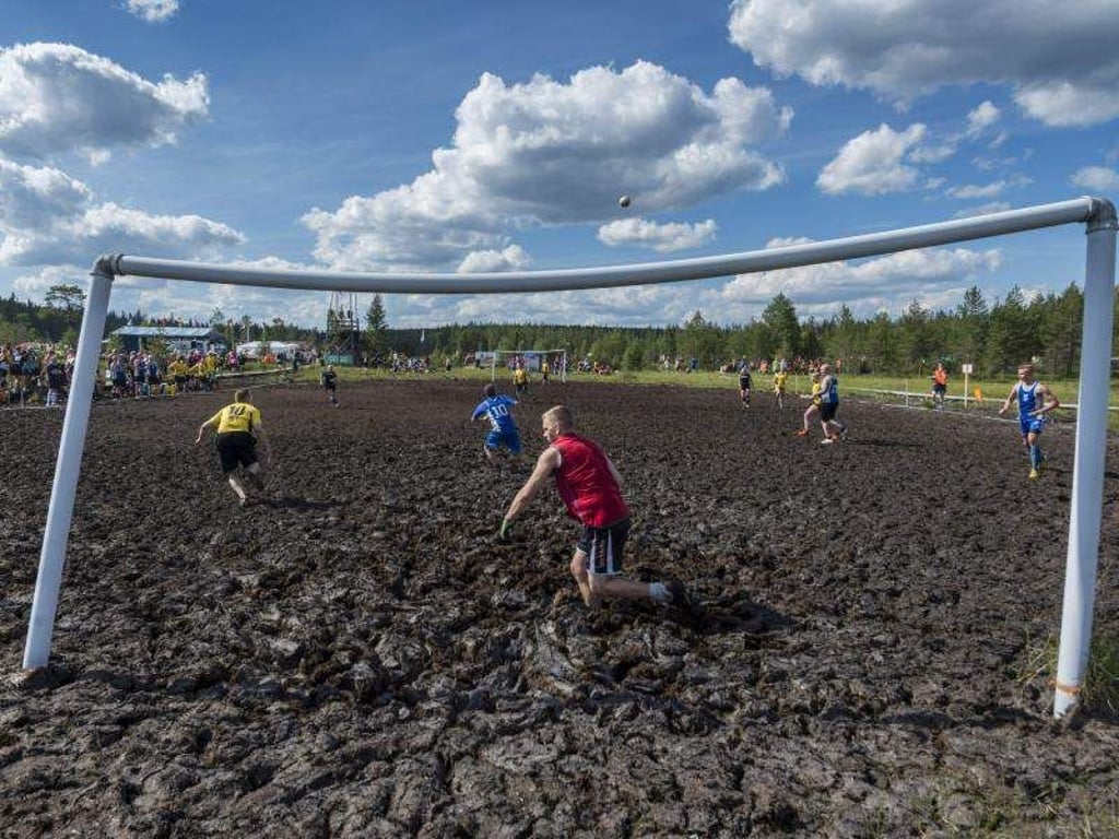 Spieler der Teams SF Rasvahapot und SuoSiat kämpfen bei der Matschfußball-Weltmeisterschaft 2018 um den Ball. Foto: Kimmo Rauatmaa