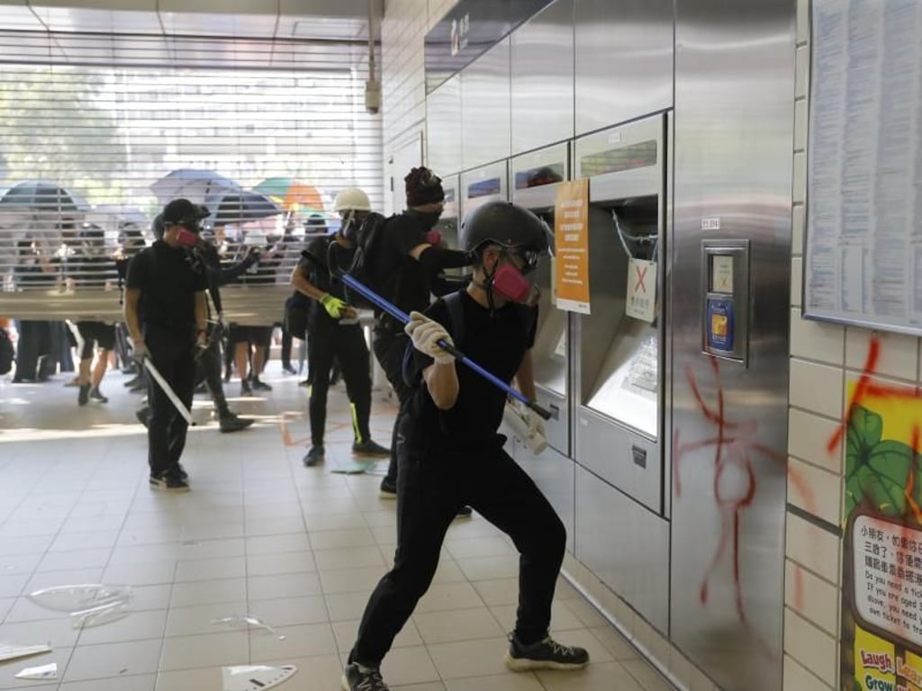 Demonstranten randalieren in der Eingangshalle einer Hongkonger U-Bahn-Station. Foto: Kin Cheung/AP/dpa