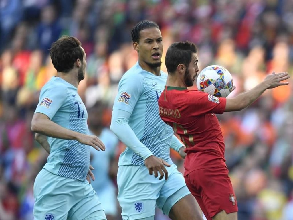 Portugals Bernardo Silva (r) nimmt den Ball vor Virgil Van Dijk mit der Brust an. Foto: Martin Meissner/AP