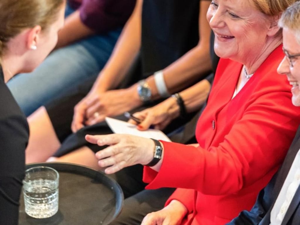 Angela Merkel lässt sich vor Beginn der Konferenz "Morals & Machines" in der Frauenkirche ein Glas Wasser servieren. Foto: Robert Michael
