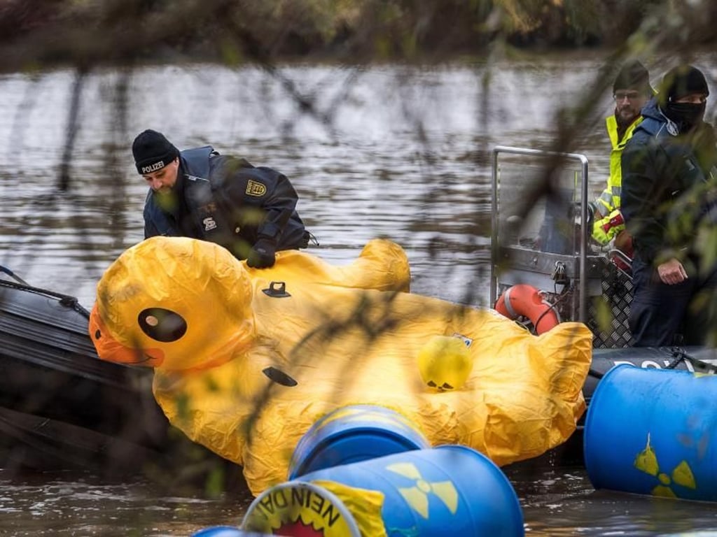 Ein Polizist fischt eine Gummiente aus dem Fluss. Foto: Sebastian Gollnow