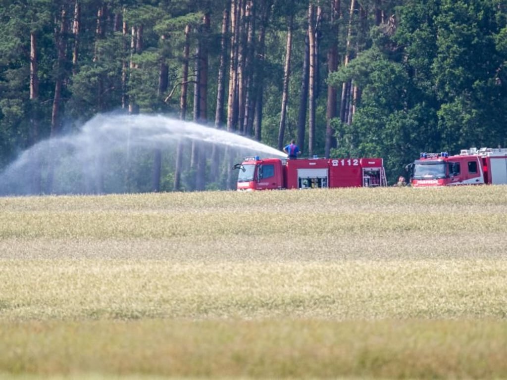 Löscharbeiten an einer der Absturzstellen in einem Feld in der Nähe von Nossentiner Hütte. Foto: Jens Büttner