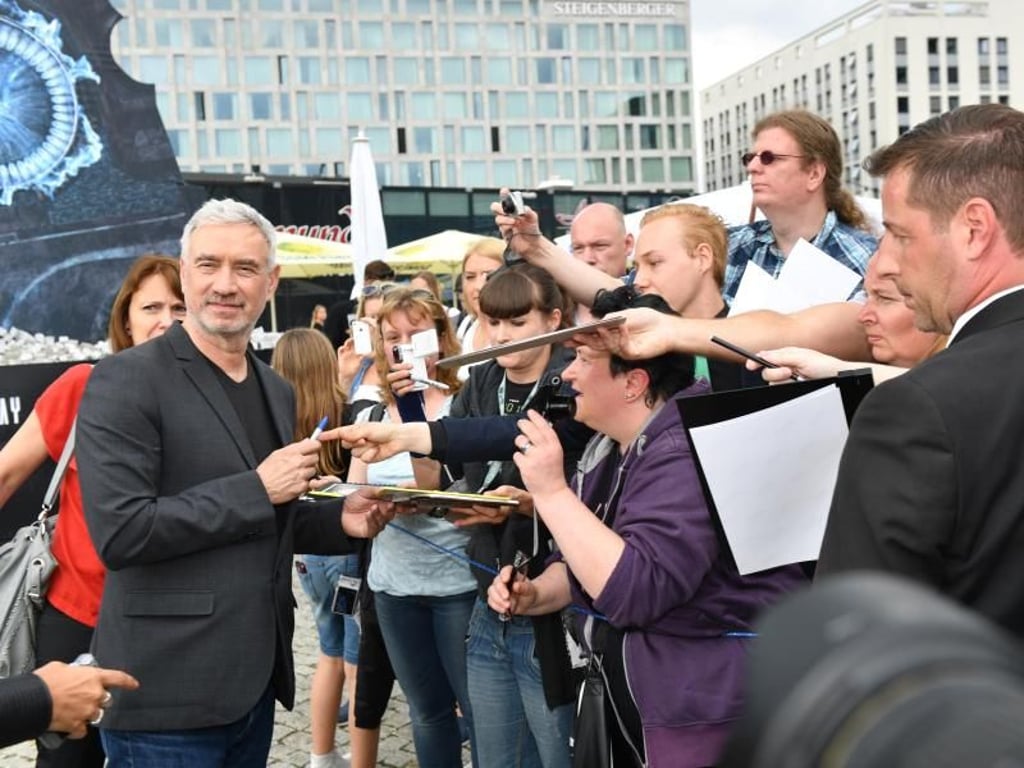 Roland Emmerich schreibt fleißig Autogramme. Foto: Jens Kalaene