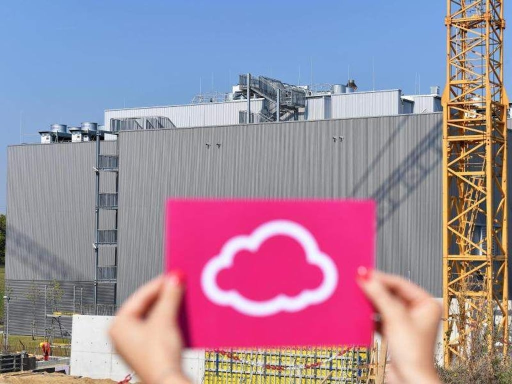 Eine Frau hält einen Zettel mit einer Wolke als Symbol für eine Cloud in die Höhe. Foto: J. Kalaene/Archiv