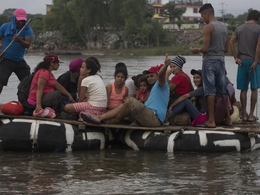 Migranten versuchen, mit einem selbstgebauten Floß den Grenzfluss Suchiate zu überqueren. Foto: Moises Castillo/AP
