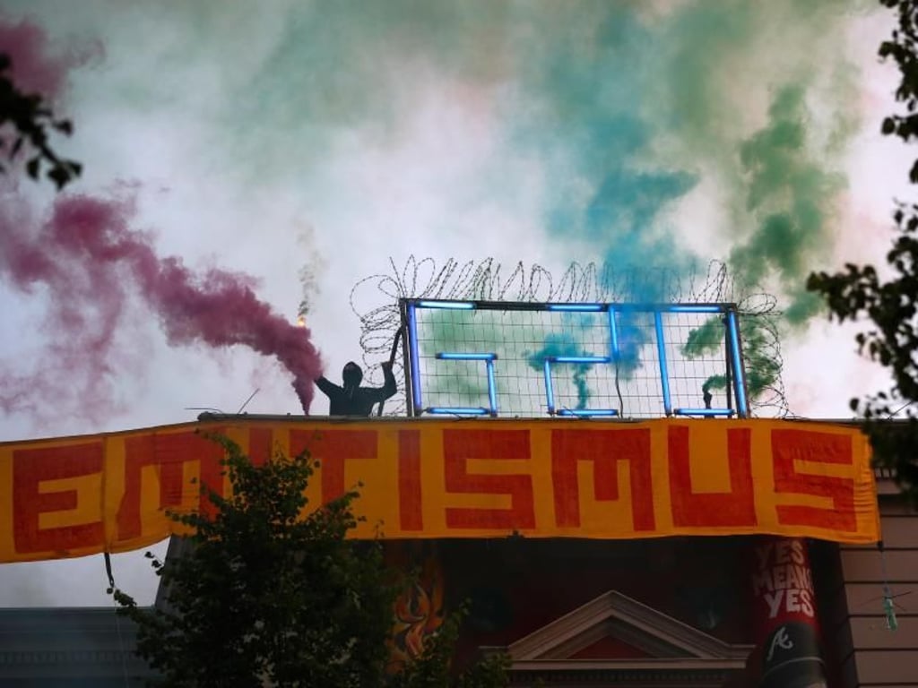 Während des G20-Gipfels: Autonomer mit Bengalos auf dem Dach der Roten Flora. Foto: Christian Charisius