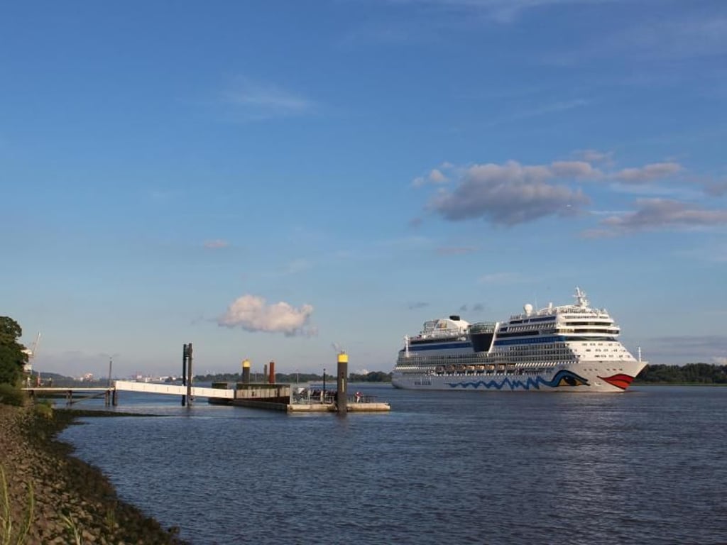 Auch ein Aida-Schiff zieht am Anleger Willkomm-Höft vorbei - was nicht so häufig vorkommt. Die Gäste an Bord tanzen allerdings nicht zur Begrüßungsmusik im Fährhaus, sondern zu eigenen Diskobeats. Foto: Deike Uhtenwoldt
