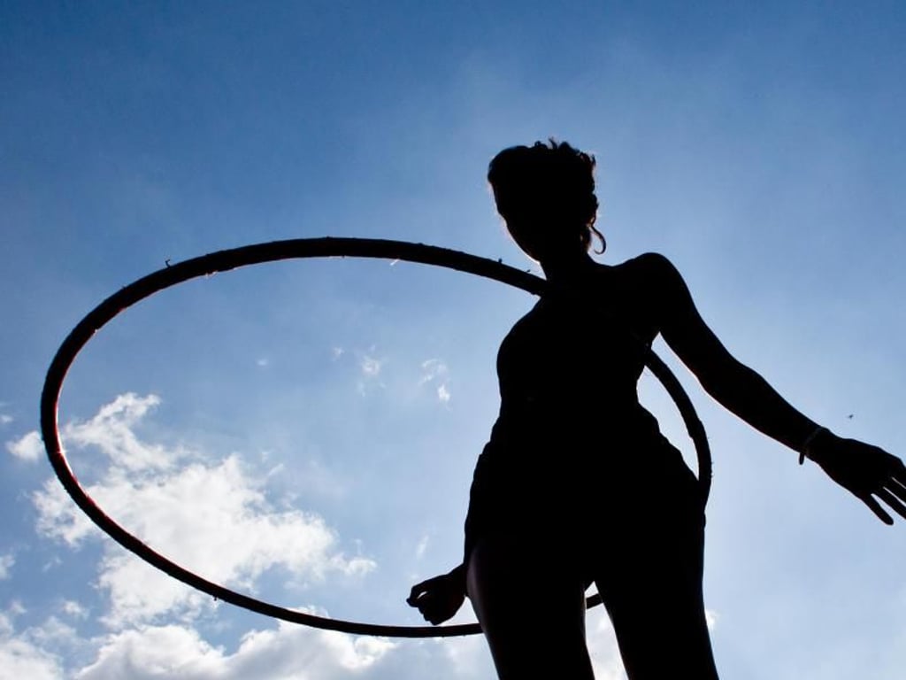 In Form: Eine junge Frau schwingt ihren Hula-Hoop-Reifen. Foto: Daniel Karmann