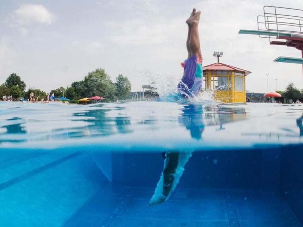 Ein Schwimmer springt in Düsseldorf vom Sprungturm ins Wasser. Foto: Jana Bauch