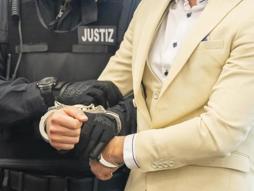 Der Angeklagte wird von einem Justizbeamten in den Gerichtssaal geführt. Foto: Matthias Rietschel
