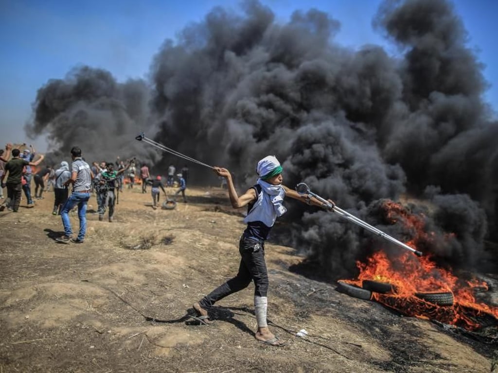 Ein Palästinenser schleudert Steine auf israelische Soldaten. Foto: Wissam Nassar