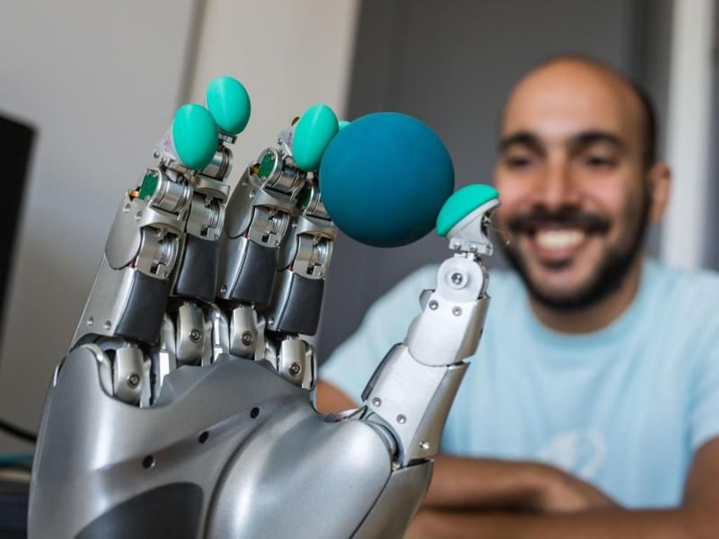Student Filipe Veiga aus Portugal (30) beobachtet, wie die von ihm programmierte Roboterhand einen Ball ertastet und festhält. Foto: Frank Rumpenhorst