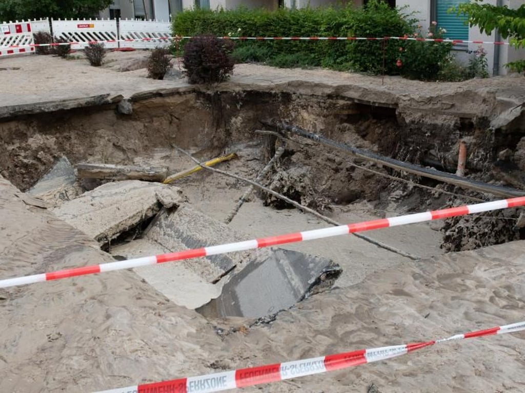 Der Krater in der Semmelweisstraße in Köpenick ist weiträumig abgesperrt. Augenzeugen berichteten, ein Busfahrer habe gerade noch rechtzeitig stoppen und zurücksetzen können, bevor die Straßendecke einbrach. Foto: Paul Zinken