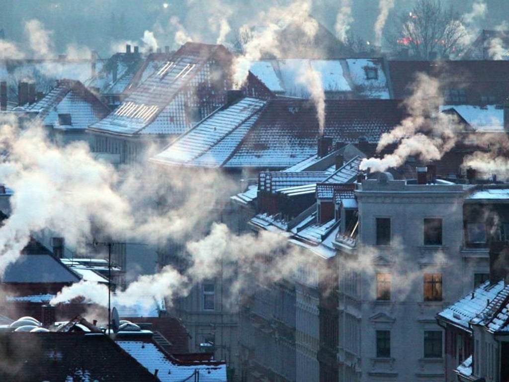 Nach einer Nacht mit Temperaturen bis zu minus 20 Grad Celsius qualmen in Leipzig die Schornsteine: Die bessere Wärmedämmung von Gebäuden kann große Mengen CO2 sparen. Foto: Jan Woitas/Archiv