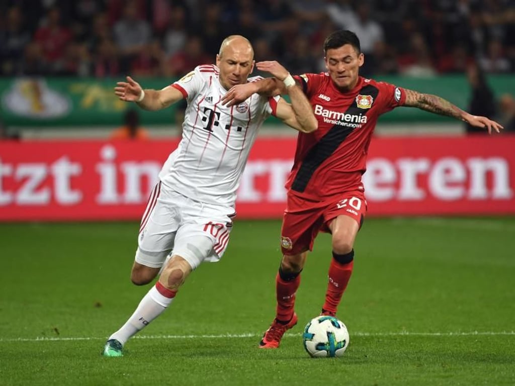 Arm in Arm: Leverkusens Charles Mariano Aranguiz (r) und Bayern-Routinier Arjen Robben beharken sich. Foto: Federico Gambarini