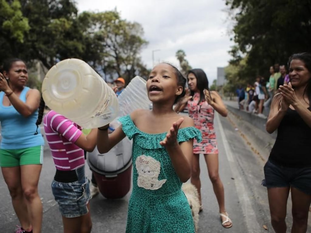 Frauen protestieren mit leeren Kanistern auf gegen den Wassermangel in Caracas. Foto: Rafael Hernandez