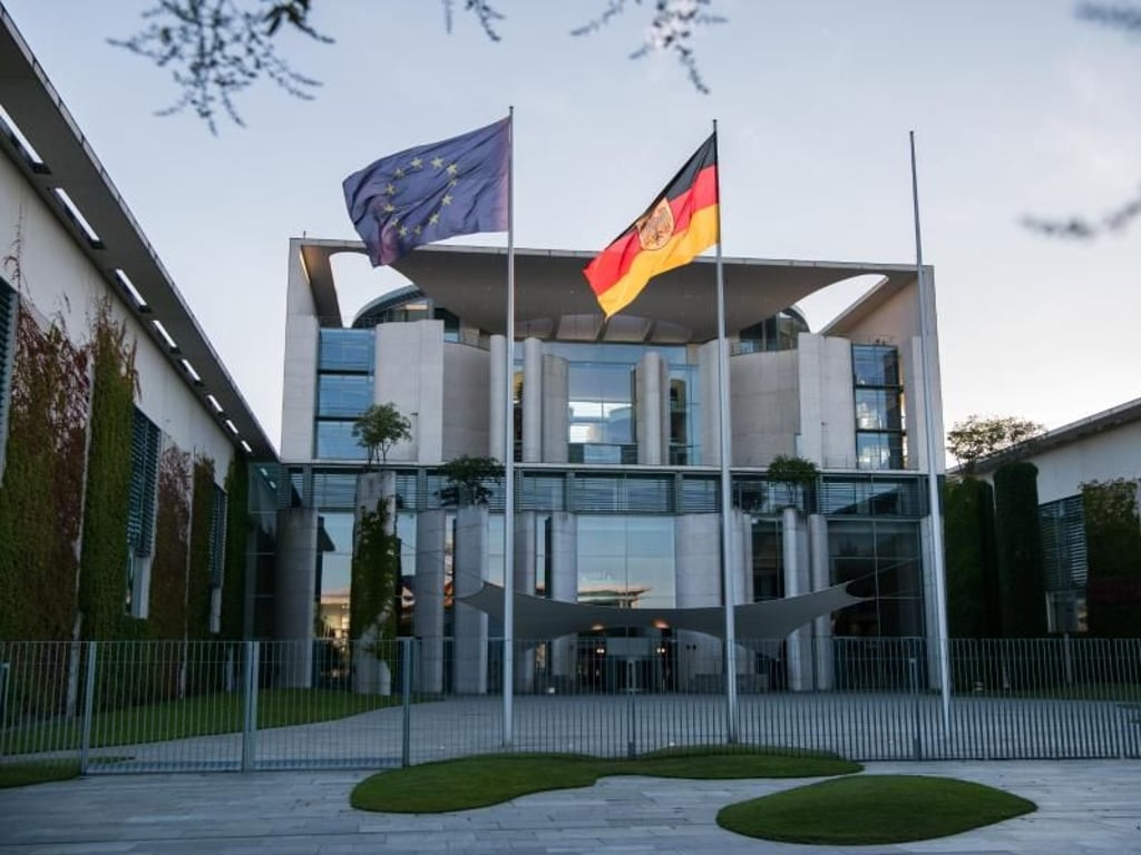 Die deutsche und die EU-Flagge vor dem Kanzleramt in Berlin. Foto: Bernd von Jutrczenka