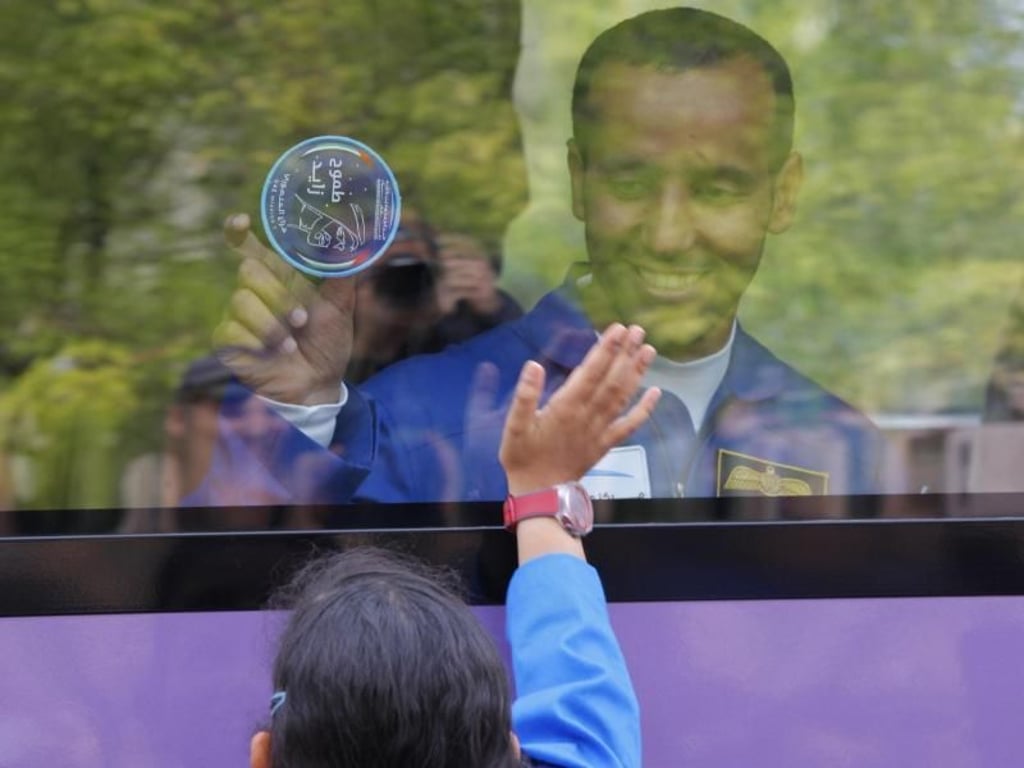 Hassa al-Mansuri winkt aus einem Bus vor dem geplanten Start der Sojus-Rakete Angehörigen zu. Foto: Dmitri Lovetsky/AP