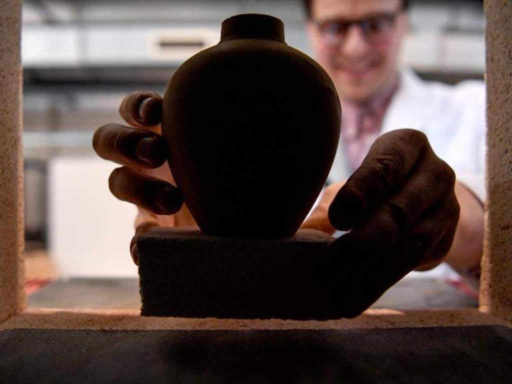 David Karl, Wissenschaftler, stellt eine Vase aus Mars-Simulant-Material in einen Keramischen Ofen. Foto: Britta Pedersen/ZB