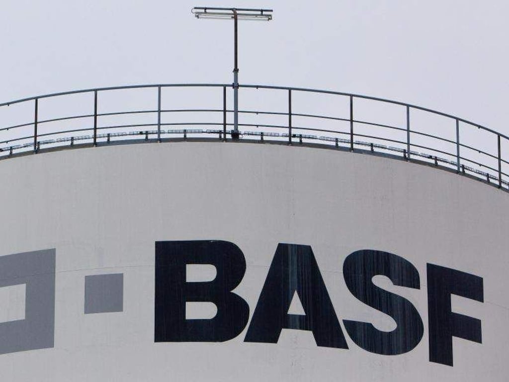 Ein Mitarbeiter der BASF Schwarzheide GmbH geht über eine Brücke zu einem Tanklager. Foto: Patrick Pleul/Archiv