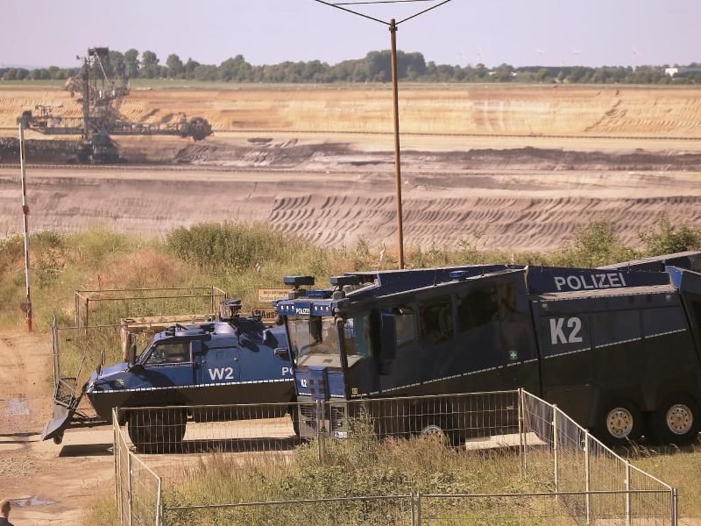 Ein gepanzertes Räumfahrzeug und ein Wasserwerfer am Rand des Braunkohle-Tagebaus Garzweiler. Foto: David Young