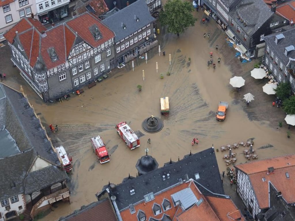 Feuerwehrfahrzeuge auf dem schlammbedeckten Marktplatz von Goslar. Foto: Stefan Rampfel/Archiv