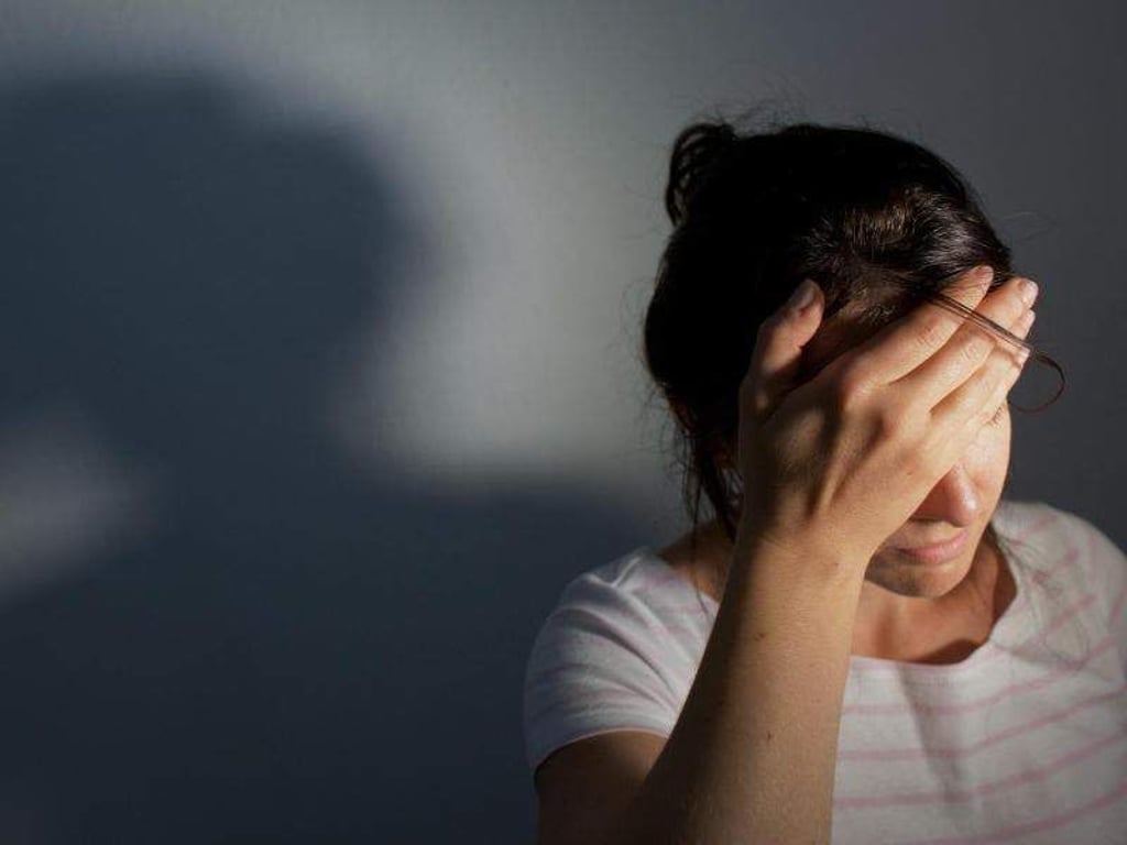 Eine junge Frau fasst sich an den Kopf. Foto: Oliver Killig/Illustration
