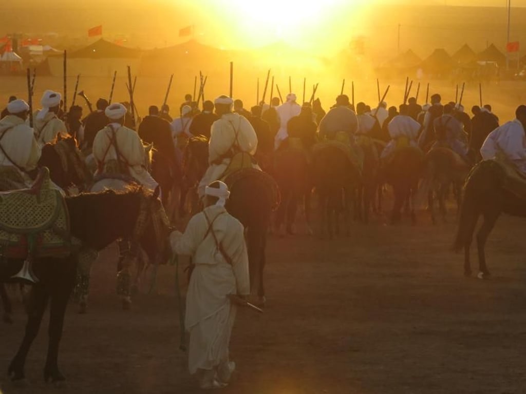 Sonnenuntergang in Tan-Tan: Zum Abschluss des Moussem-Festivals formieren sich noch einmal die Beduinen-Reiter aller Stämme mit ihren Pferden und Kamelen. Foto: Markus Steiner