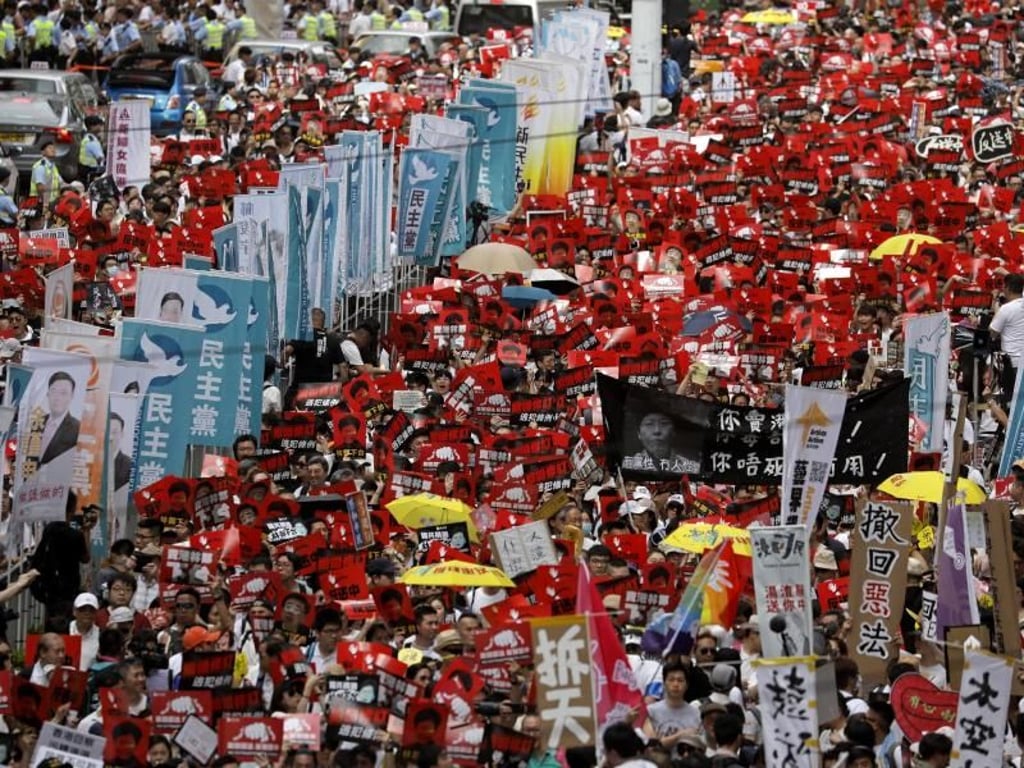 Bei einer Massen-Kundgebung in Hongkong tragen die Teilnehmer Fahnen und Plakate. Foto: Vincent Yu/AP
