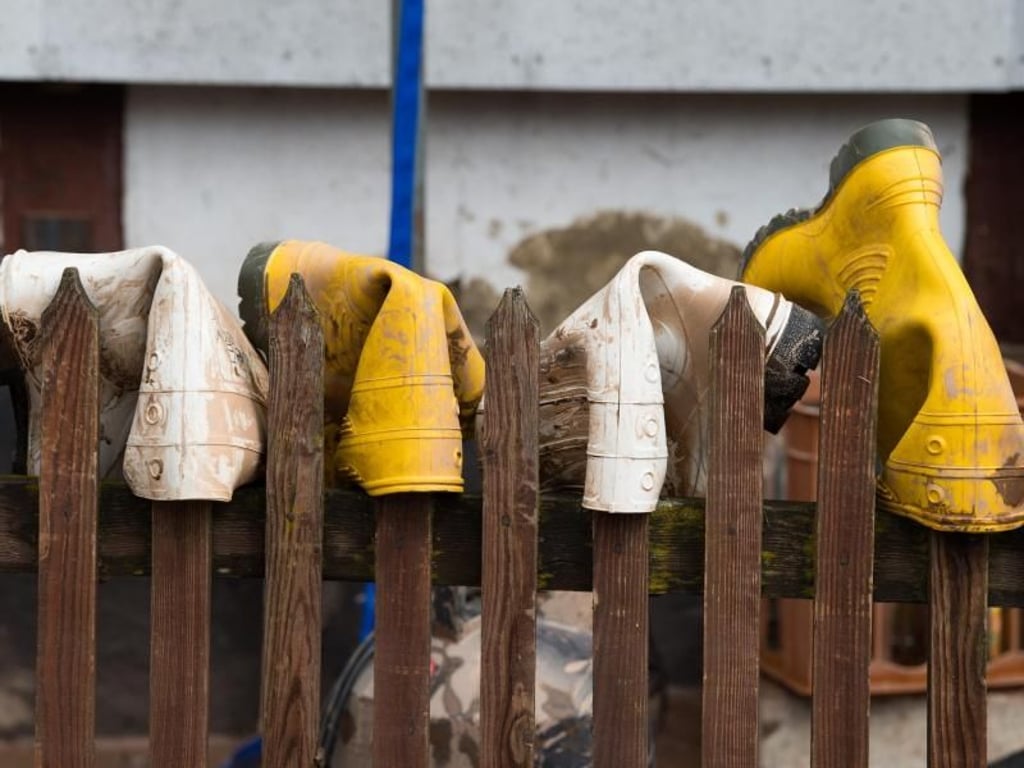Gummistiefel sind in Rhüden zum Trocknen auf die Latten eines Gartenzauns gestülpt. Foto: Swen Pförtner