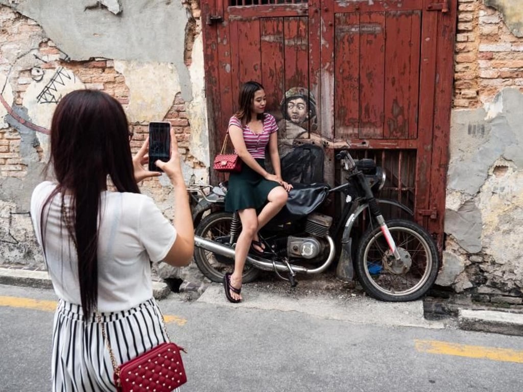 Modernes Malaysia: Diese Frauen posieren vor einem Street-Art-Gemälde in der Altstadt von George Town. Foto: Andreas Drouve