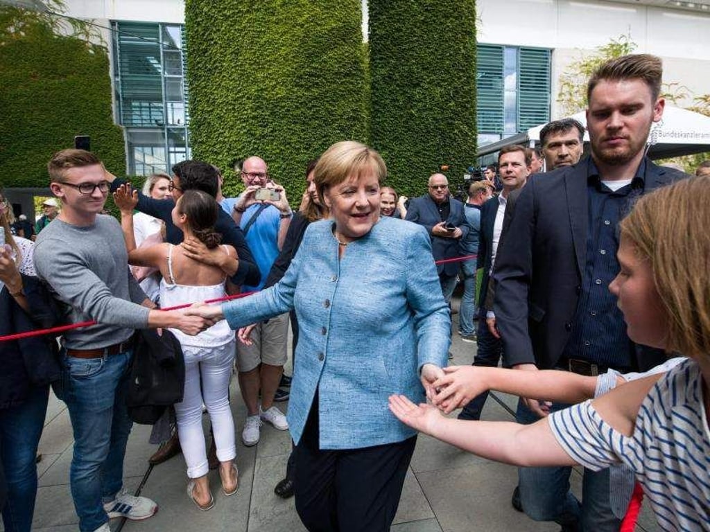 Angela Merkel begrüßt Besucher auf dem Gelände des Bundeskanzleramts. Foto: Bernd von Jutrczenka