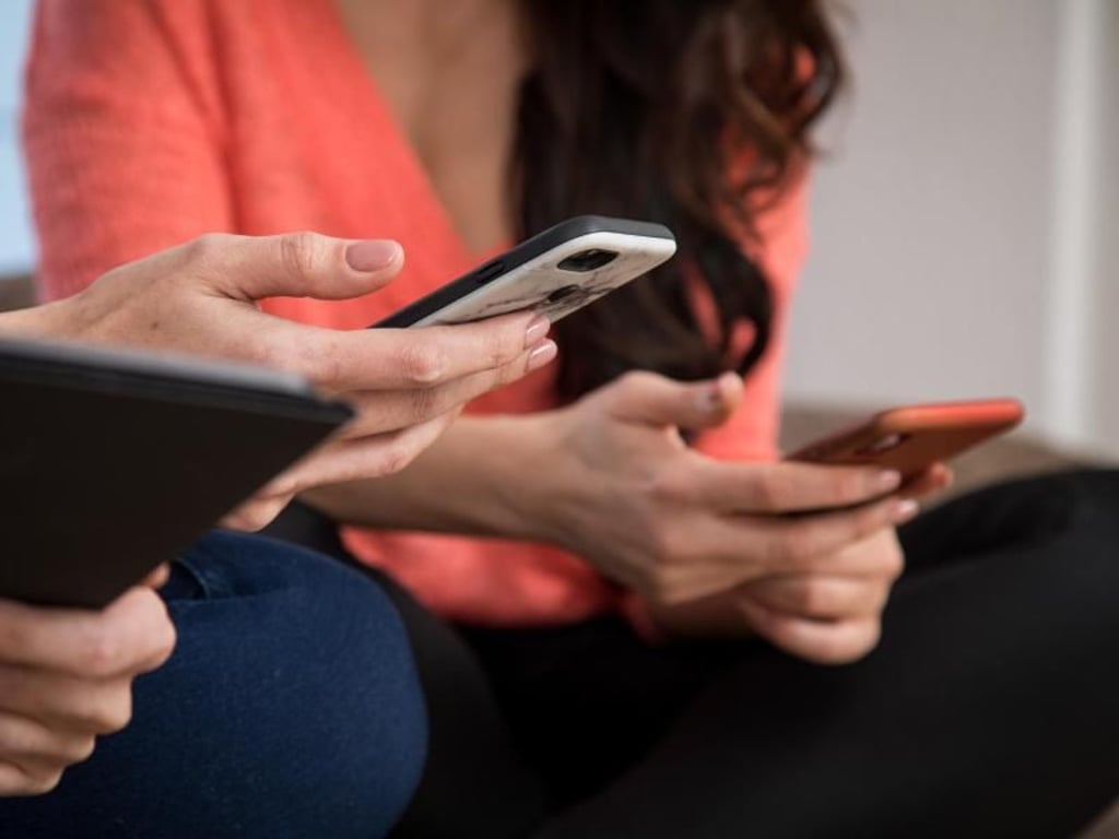 Selbst beim Treffen mit Freunden geht der Griff immer wieder Richtung Smartphone. Ein Trick dagegen: Alle Geräte auf einem Haufen stapeln - wer zuerst seines heraus zieht, muss eine Runde Getränke zahlen. Foto: Christin Klose/dpa-tmn