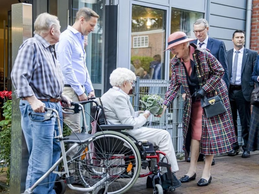 Margrethe II. (r), Königin von Dänemark, bekommt von Liselotte Wilms vor einem dänischen Altenheim einen Blumenstrauß. Foto: Axel Heimken