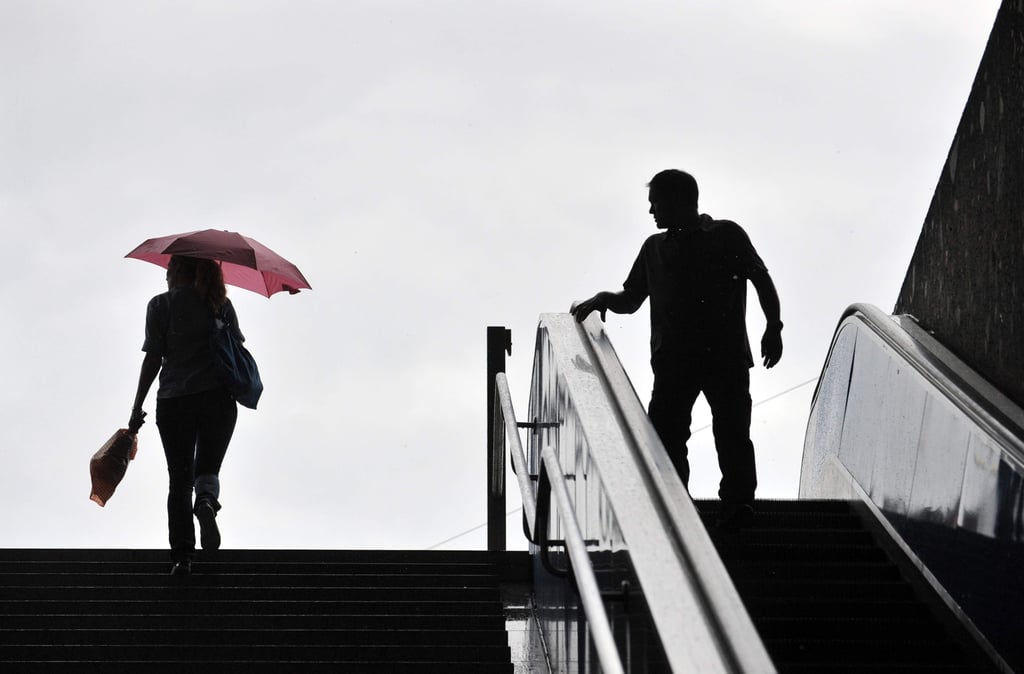 ARCHIV - ILLUSTRATION - Eine Frau mit Schirm geht am 02.08.2010 in München (Bayern) an der U-Bahnstation Sendlinger Tor eine Treppe hoch, während ihr ein Mann hinterherschaut. Foto: Andreas Gebert dpa/lby (zu dpa ««Kommst du mit uns spielen?» - Belgien bestraft öffentlichen Sexismus» vom 04.05.2016) +++ dpa-Bildfunk +++