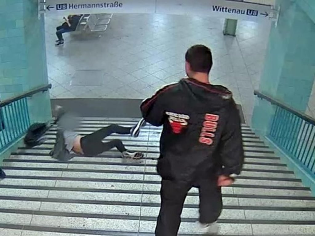 Ein Mann wird am U-Bahnhof Alexanderplatz in Berlin die Treppe heruntergestoßen. Foto: Polizei Berlin