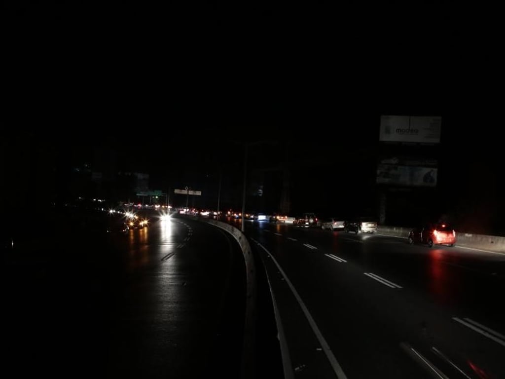 Autos fahren auf einer stockdunklen Autobahn durch die venezolanische Hauptstadt. Zwar wurden nach und nach Teile des Landes wieder an das Stromnetz angeschlossen, allerdings kommt es bei den Arbeiten ständig zu Rückschlägen. Foto: Rafael Hernandez