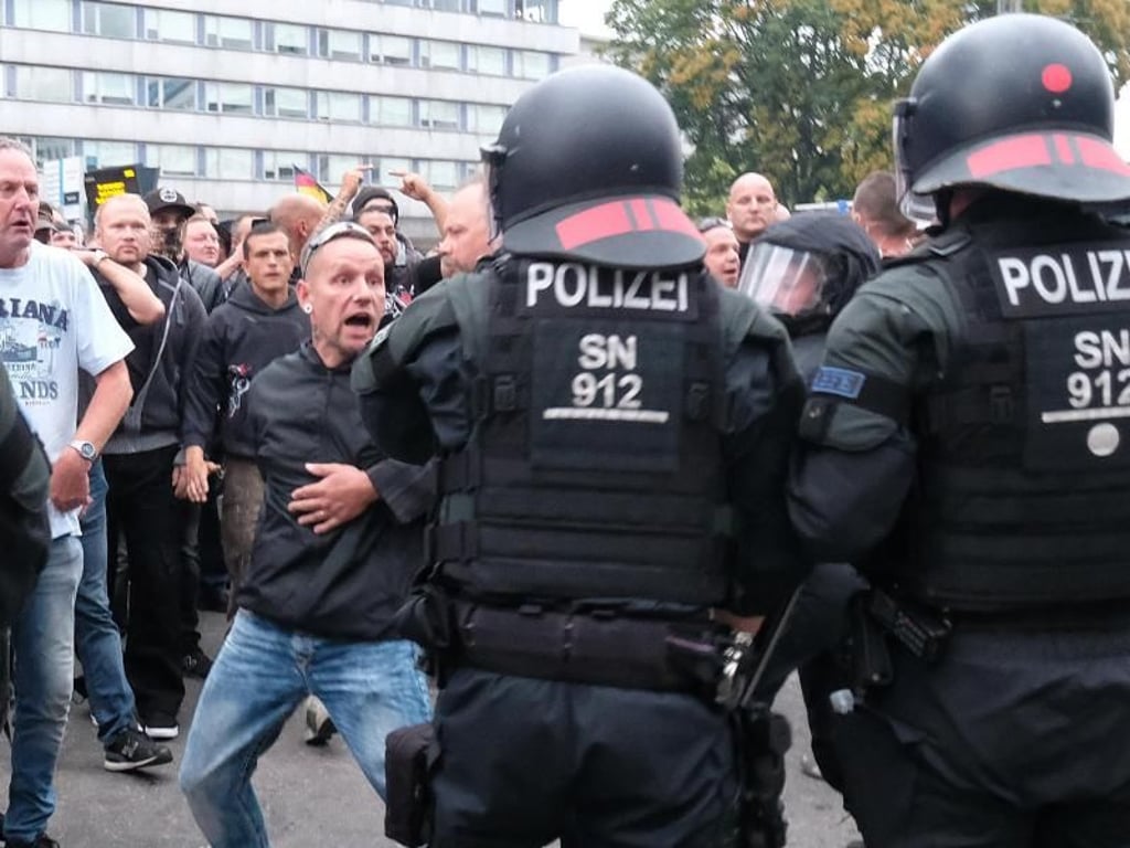 Wutverzerrtes Gesicht: Polizisten versuchen in der Chemnitzer Innenstadt, ein Aufeinanderprallen von rechten und linken Gruppen zu verhindern. Foto: Sebastian Willnow