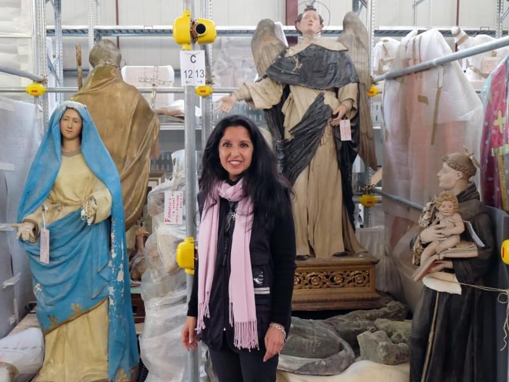 Cristina Collettini, Standortleiterin der Lagerhalle in Cittaducale, vor geretteten religiösen Statuen. Foto: Alvise Armellini