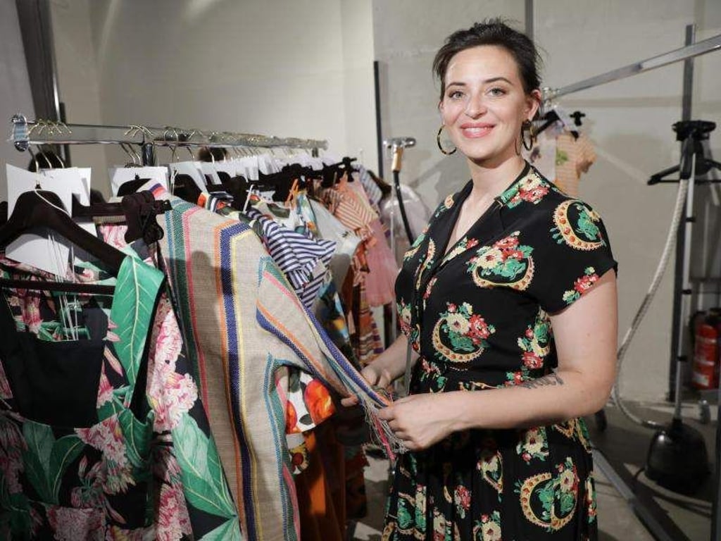 Designerin Lena Hoschek neben ihren Kleidern auf der Fashion Week 2018. Foto: Jörg Carstensen