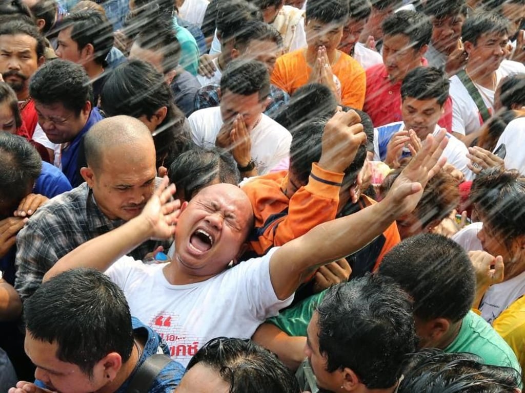 Die Tätowierten werden mit heiligem Wasser besprüht. Einige geraten dabei in Trance. Foto: Narong Sangnak