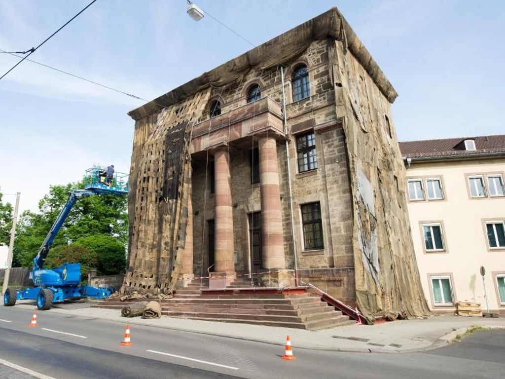 Ibrahim Mahama verhüllt die historische Torwache in Kassel mit Jutesäcken. Foto: Swen Pförtner