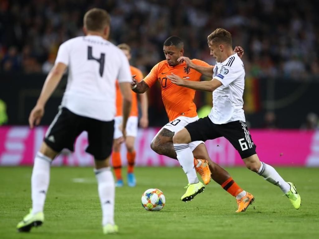 Joshua Kimmich (r) attackiert Memphis Depay. Foto: Christian Charisius