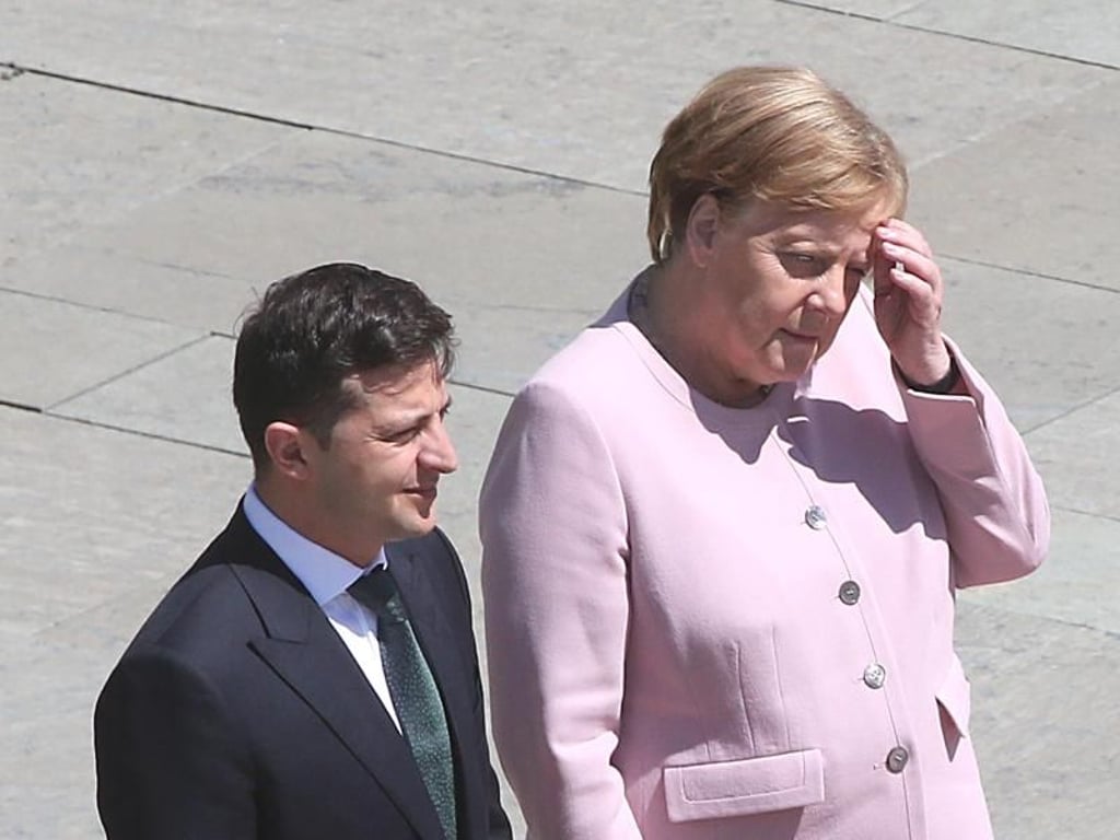 Kanzlerin Merkel und der ukrainische Präsident Selenskyj warten auf das Abschreiten der Ehrenformation der Bundeswehr. Foto: Wolfgang Kumm