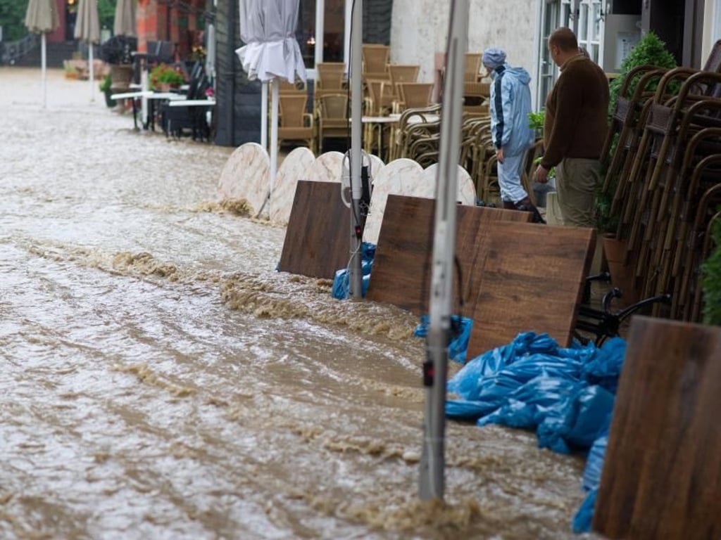 Notdürftig schützen sich Anwohner in der historischen Altstadt von Goslar vor den Wassermassen. Foto: Swen Pförtner