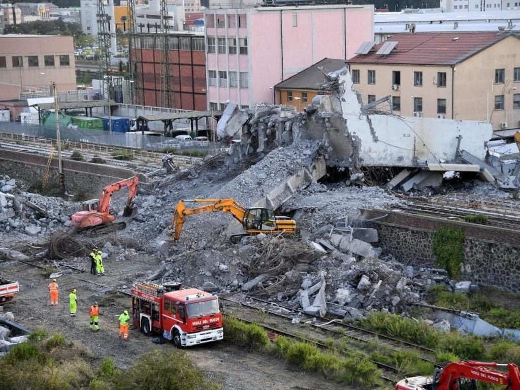 Feuerwehrleute entfernen Trümmer der teilweise eingestürzten Morandi-Autobahnbrücke in Genua. Foto: Luca Zennaro/ANSA