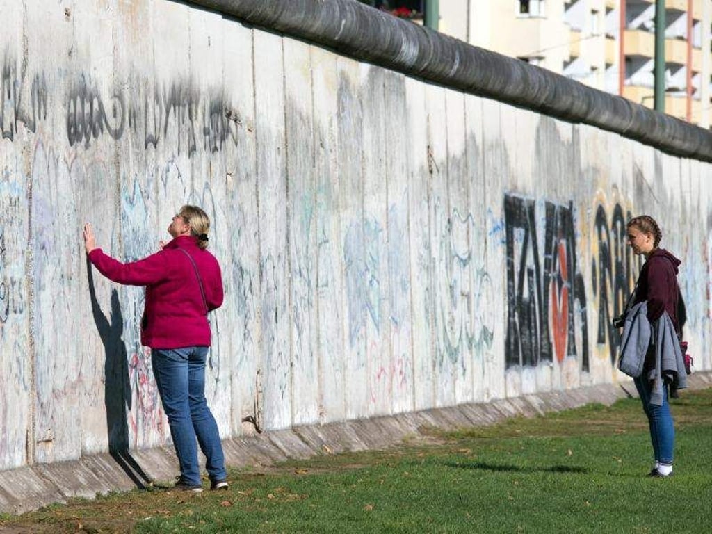 Touristen besuchen die Mauergedenkstätte an der Bernauer Straße in Berlin. Foto: Jens Büttner/Archivbild