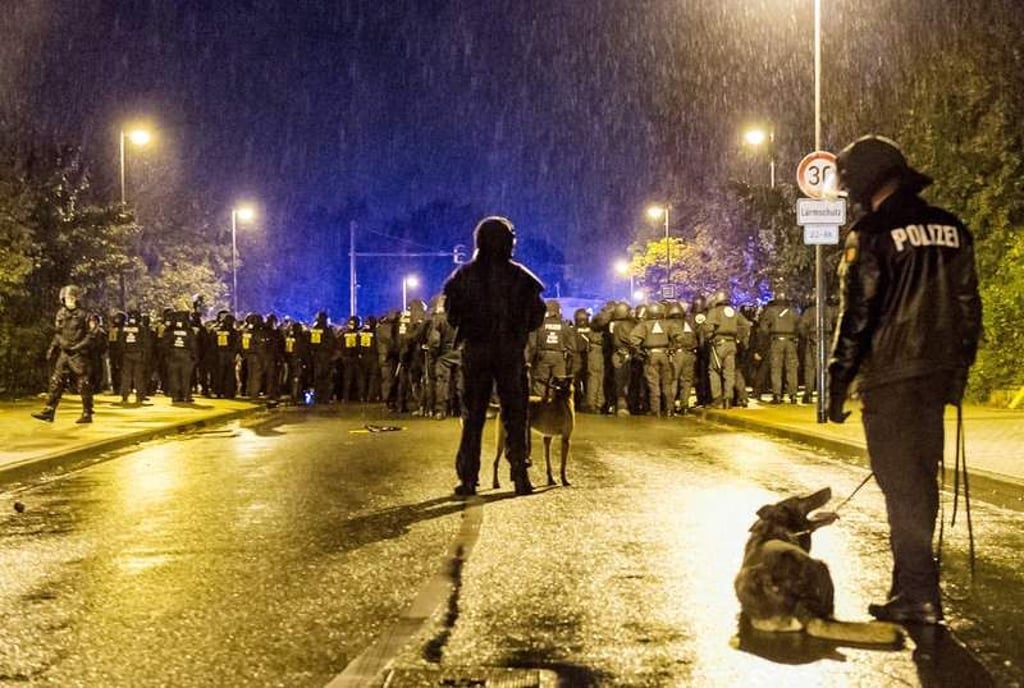 ARCHIV - Polizisten stehen am 07.10.2014 in Celle (Niedersachsen) vor einer Gruppe protestierender Jesiden. Nach den gewaltsamen Auseinandersetzungen zwischen jesidischen Kurden und muslimischen Tschetschenen in Celle im Oktober 2014 muss sich ein 31-Jähriger vom 06.02.2015 an wegen versuchten Totschlags vor dem Landgericht Lüneburg verantworten. Foto: Benjamin Westhoff/dpa (zu lni "Prozess wegen versuchten Totschlags nach Celler Krawallen" vom 06.02.2015) +++(c) dpa - Bildfunk+++